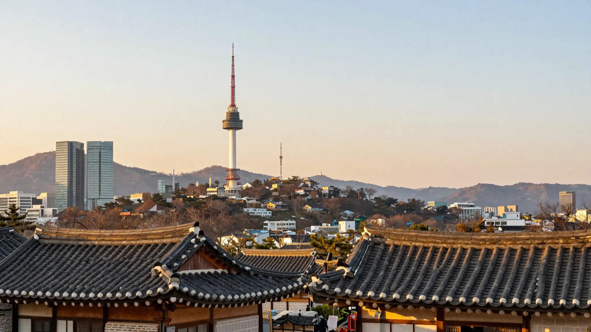 코리아 대한민국 서울의 남산타워와 한옥 지붕, 현대 고층 빌딩과 산이 어우러진 노을 풍경